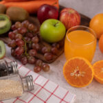 Orange cut in half with grapes and orange juice.